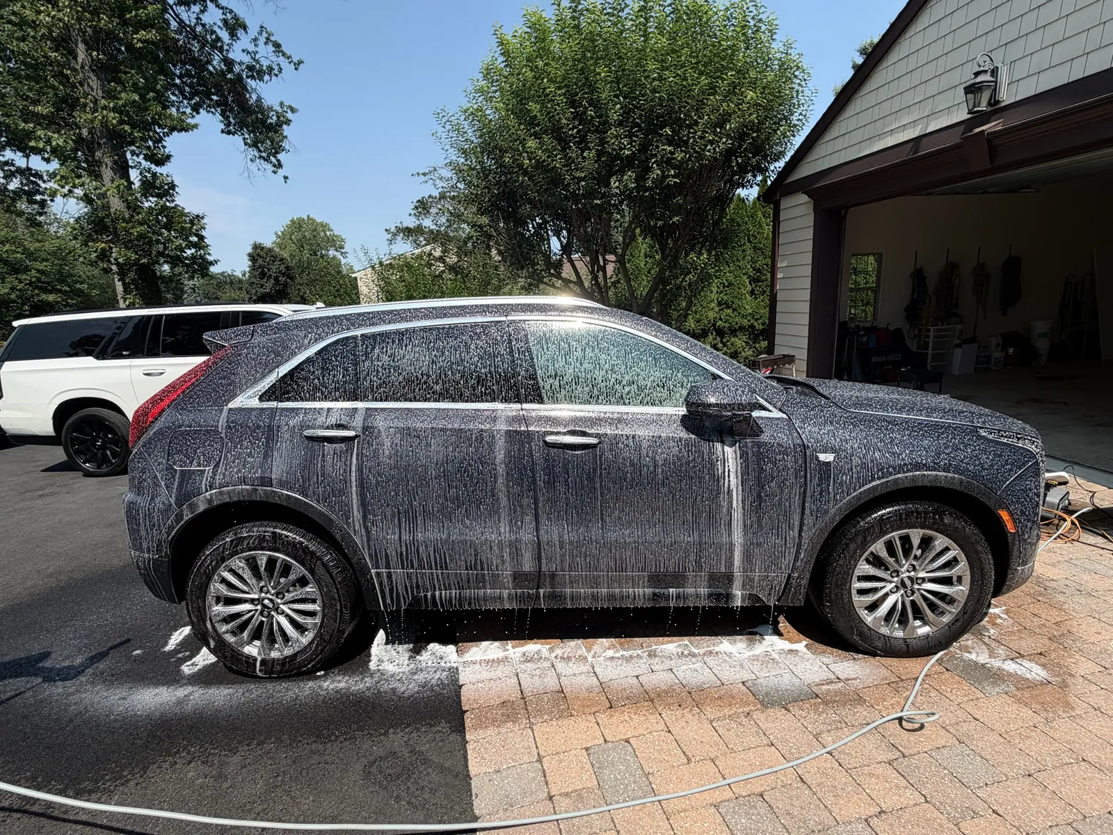 Cadillac covered in snow foam during an exterior wash